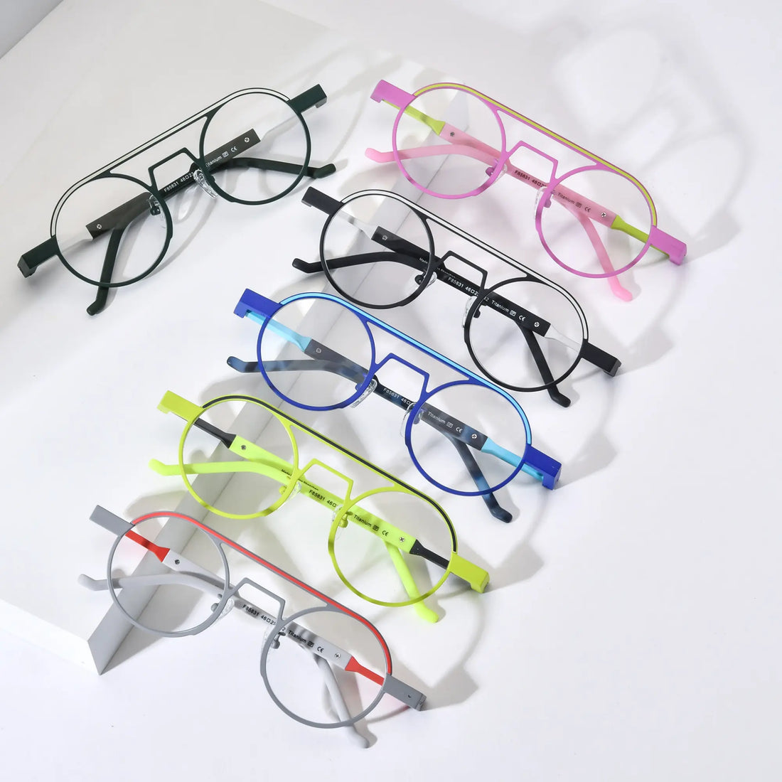 Top-down view of VoyueLens™ NeoPilot titanium aviator glasses in six vibrant color-block variants including Candy Lime, Graphite Black, Glacier Blue, Neon Moss, Urban Ink, and Chrome Ember – lightweight and prescription-ready eyewear.