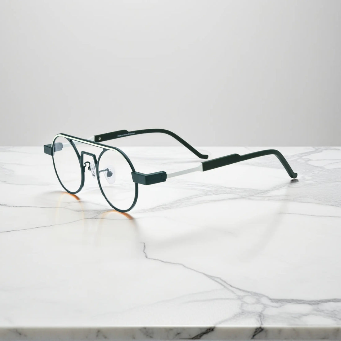 Side profile showing the slim titanium arms and hinge structure in Urban Ink deep green-gray combination for sophisticated style