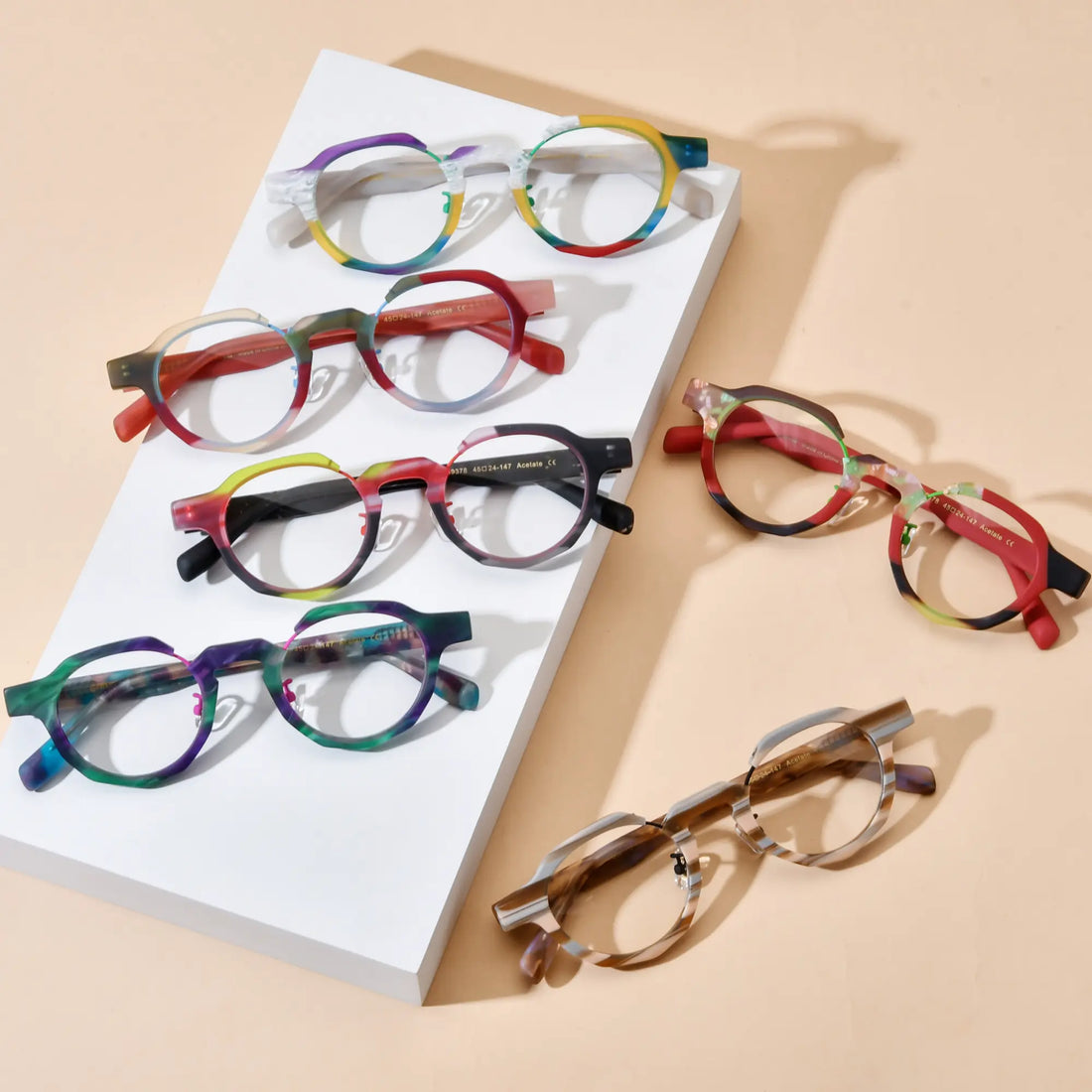 Top view of VoyueLens™ VL19378 eyeglasses in six color variants including Rainbow Frost, Rose Blush, Forest Ember, Mosaic Teal, Midnight Flame, and Amber Drift displayed on a beige background