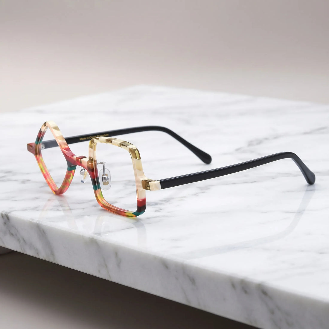 Barledear Amber Mosaic asymmetric geometric acetate eyeglasses angled side view showing the layered warm-tone frame, metal hinges, and slim black temples.