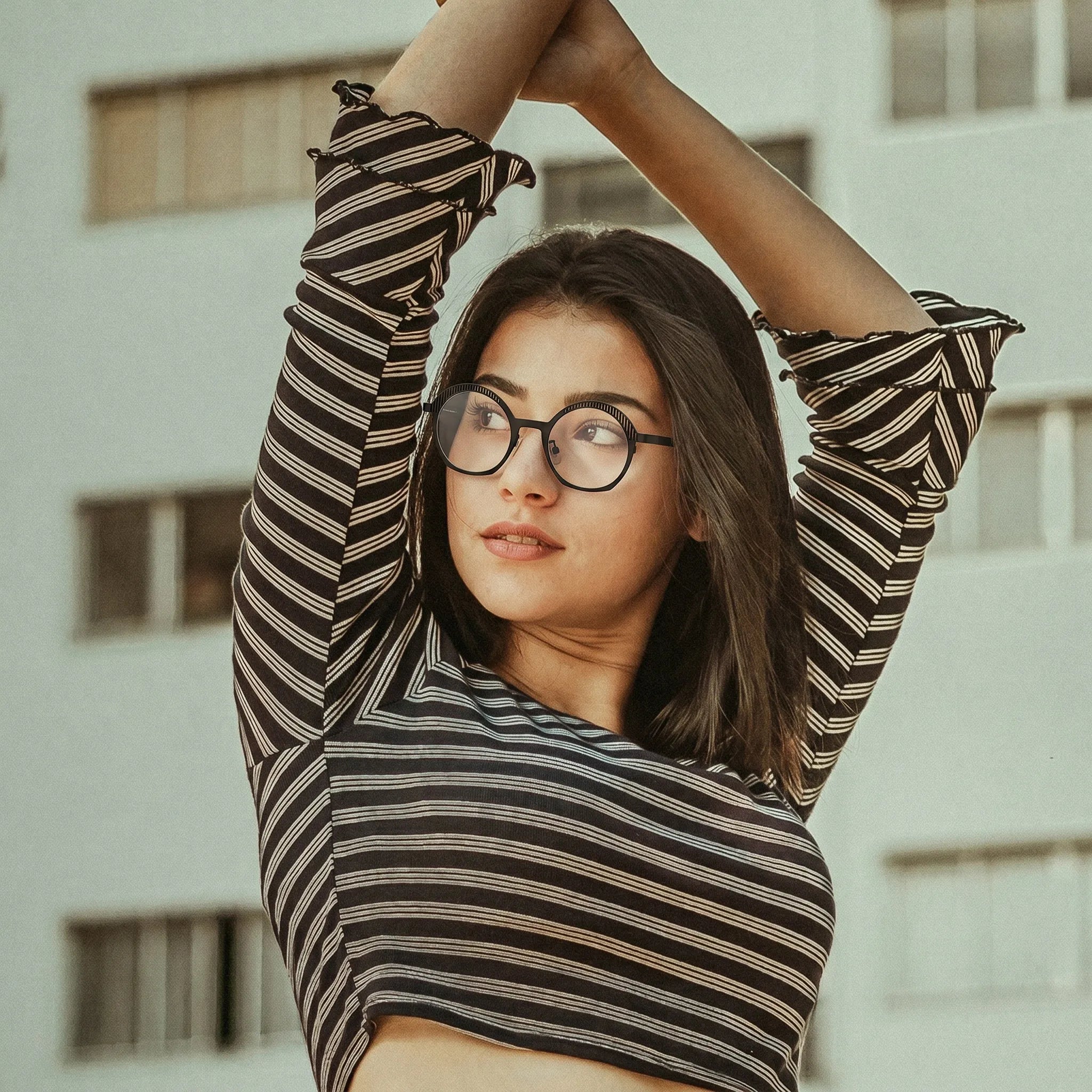 Model wearing Barledear Charcoal Black eyeglasses in a lifestyle portrait with clean lightweight geometric titanium frame