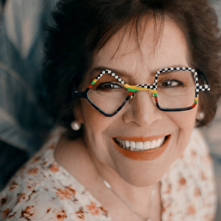 Adult model wearing Barledear Checkerboard Spectrum asymmetric geometric acetate eyeglasses in a bold modern street-style portrait.