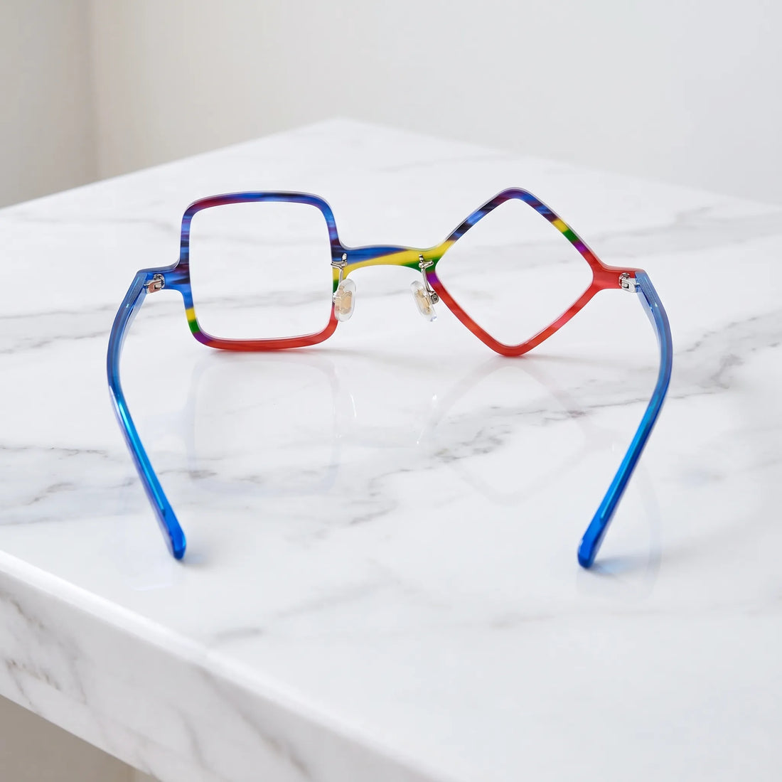 Barledear Cobalt Crimson asymmetric geometric acetate eyeglasses back view showing the mismatched geometric shapes, clear nose pads, and cobalt-blue temple structure.