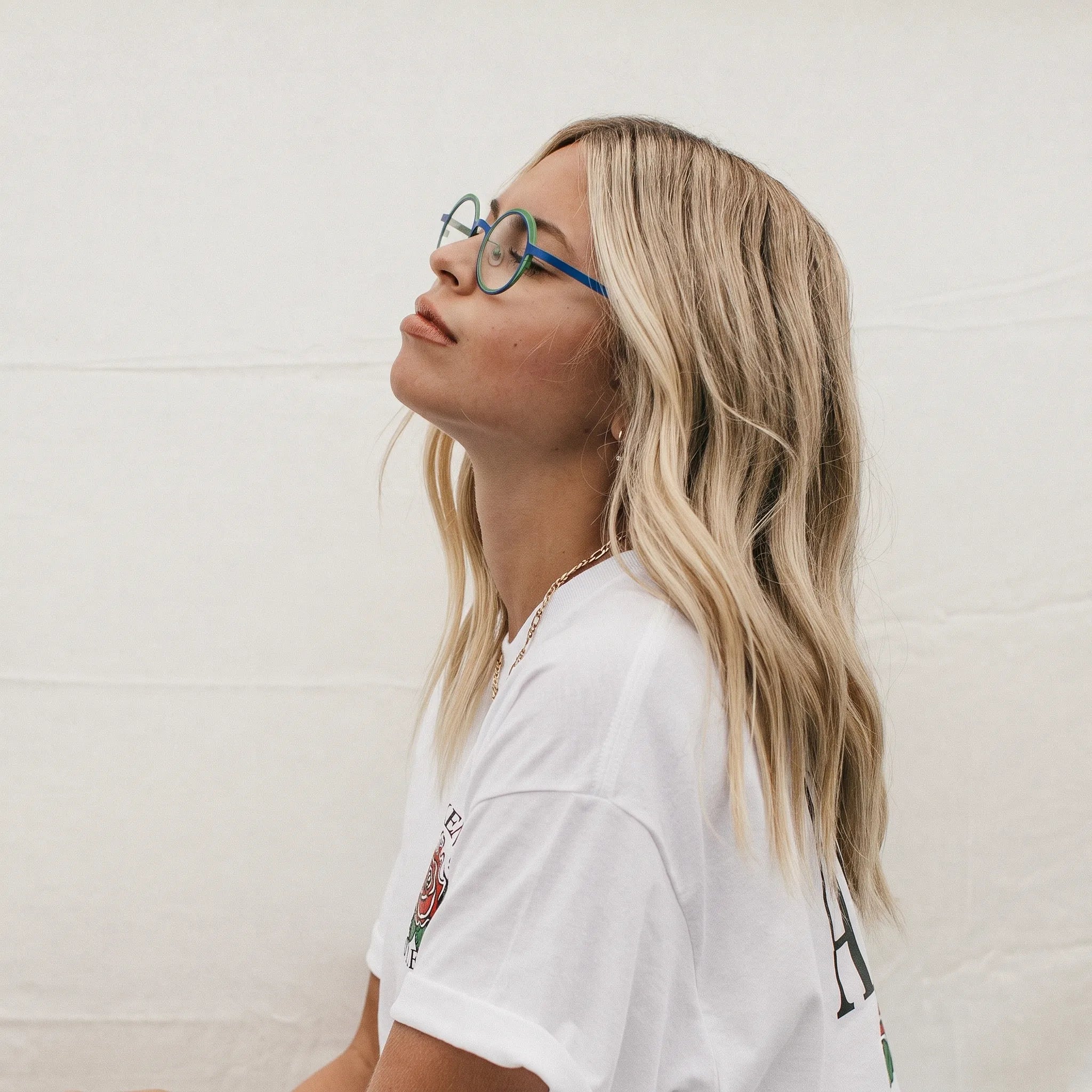 Model wearing Barledear Cobalt Jade round pure titanium eyeglasses in a lifestyle portrait showing a lightweight design for everyday wear