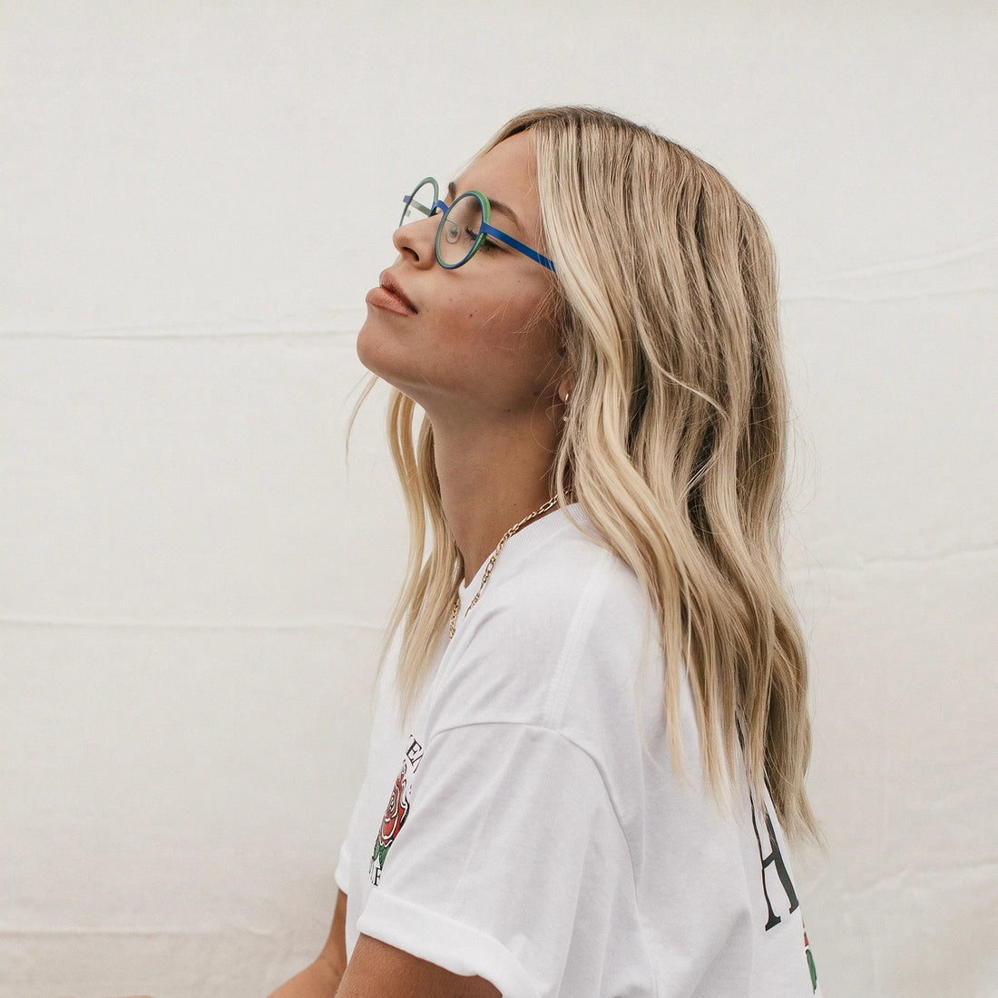 Model wearing Barledear Cobalt Jade round pure titanium eyeglasses in a lifestyle portrait showing a lightweight design for everyday wear