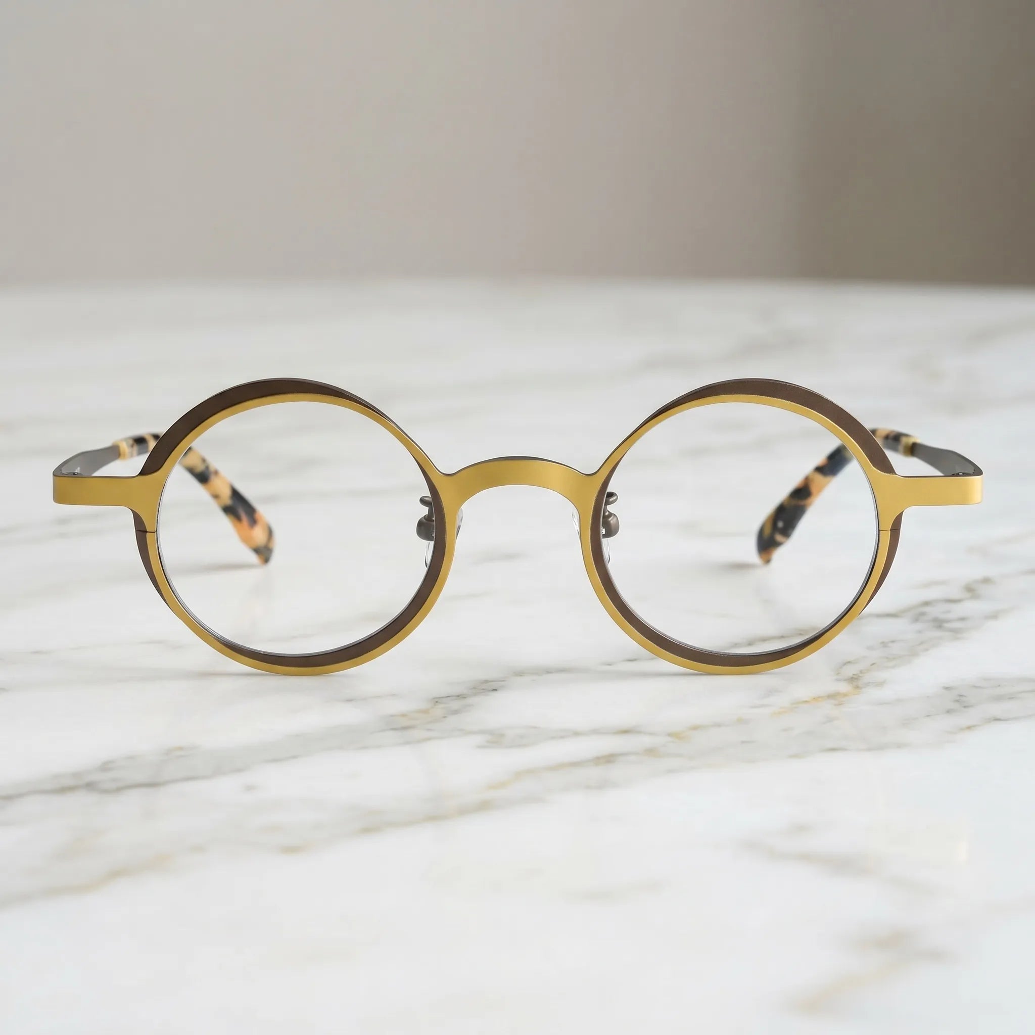 Barledear Golden Walnut round titanium eyeglasses displayed in a clean lifestyle scene showing the artistic color-block design in warm golden yellow and deep brown