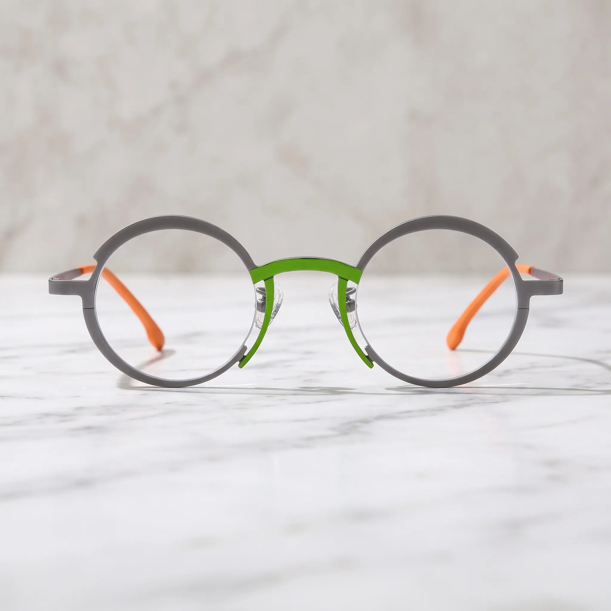 Barledear Graphite Gray Citrus Orange eyeglasses lifestyle front view showing the artistic round titanium frame and contrasting color details