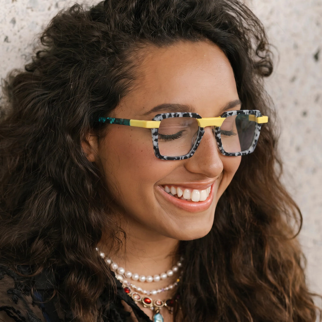 Model wearing Barledear Lemon Teal Mosaic square eyeglasses in a colorful lifestyle portrait