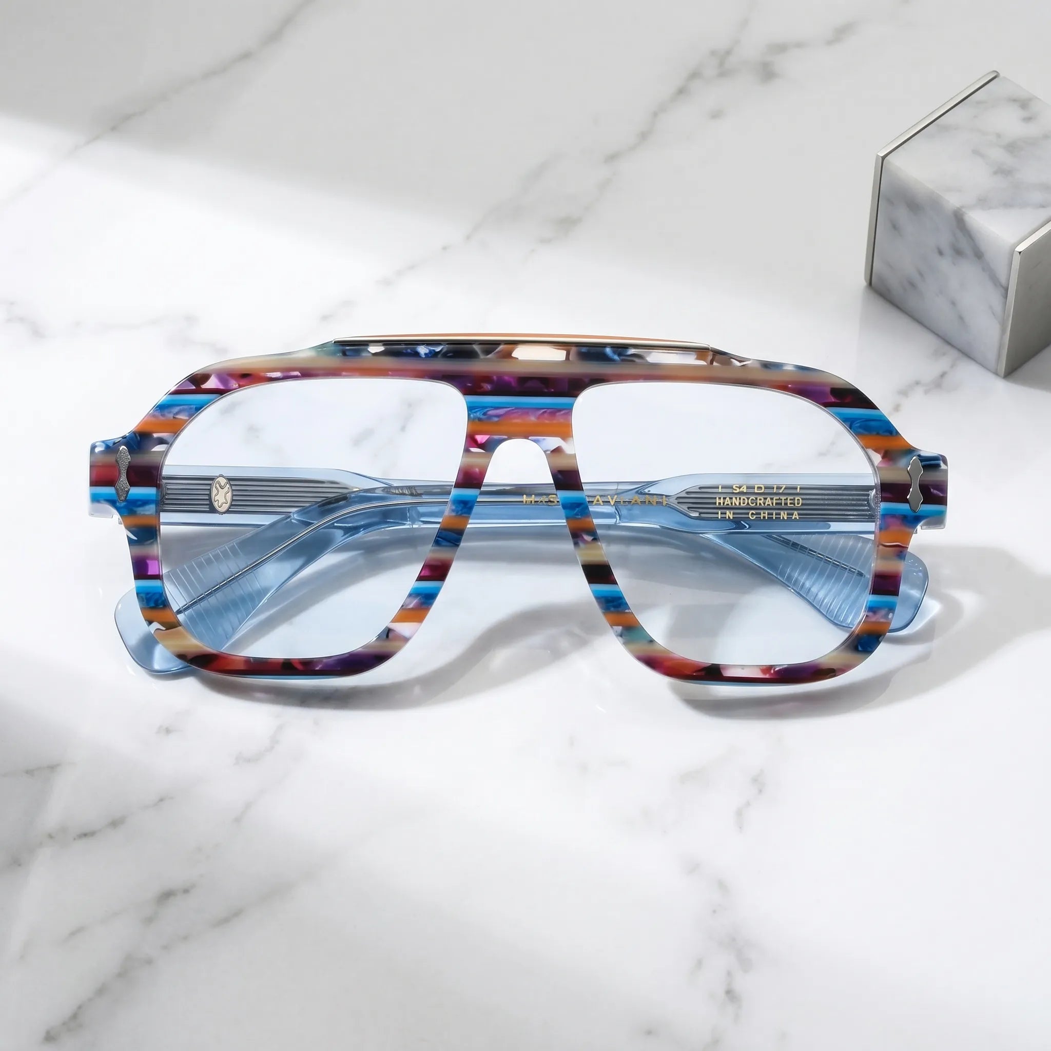 Barledear Prism Blue Mosaic eyeglasses folded display showing the thick acetate front, translucent blue temples and decorative metal hinge details