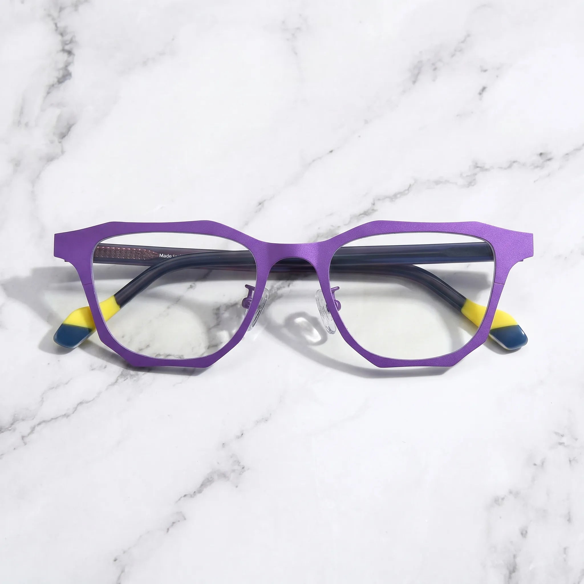 Barledear Violet Shadow eyeglasses folded display showing dark temples, yellow temple tips, and geometric frame styling