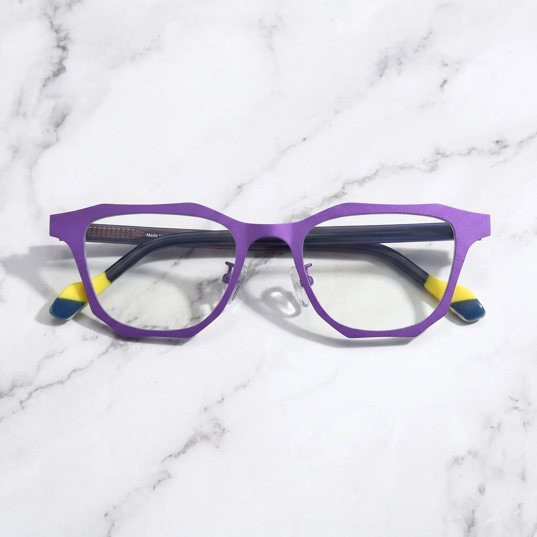 Barledear Violet Shadow eyeglasses folded display showing dark temples, yellow temple tips, and geometric frame styling