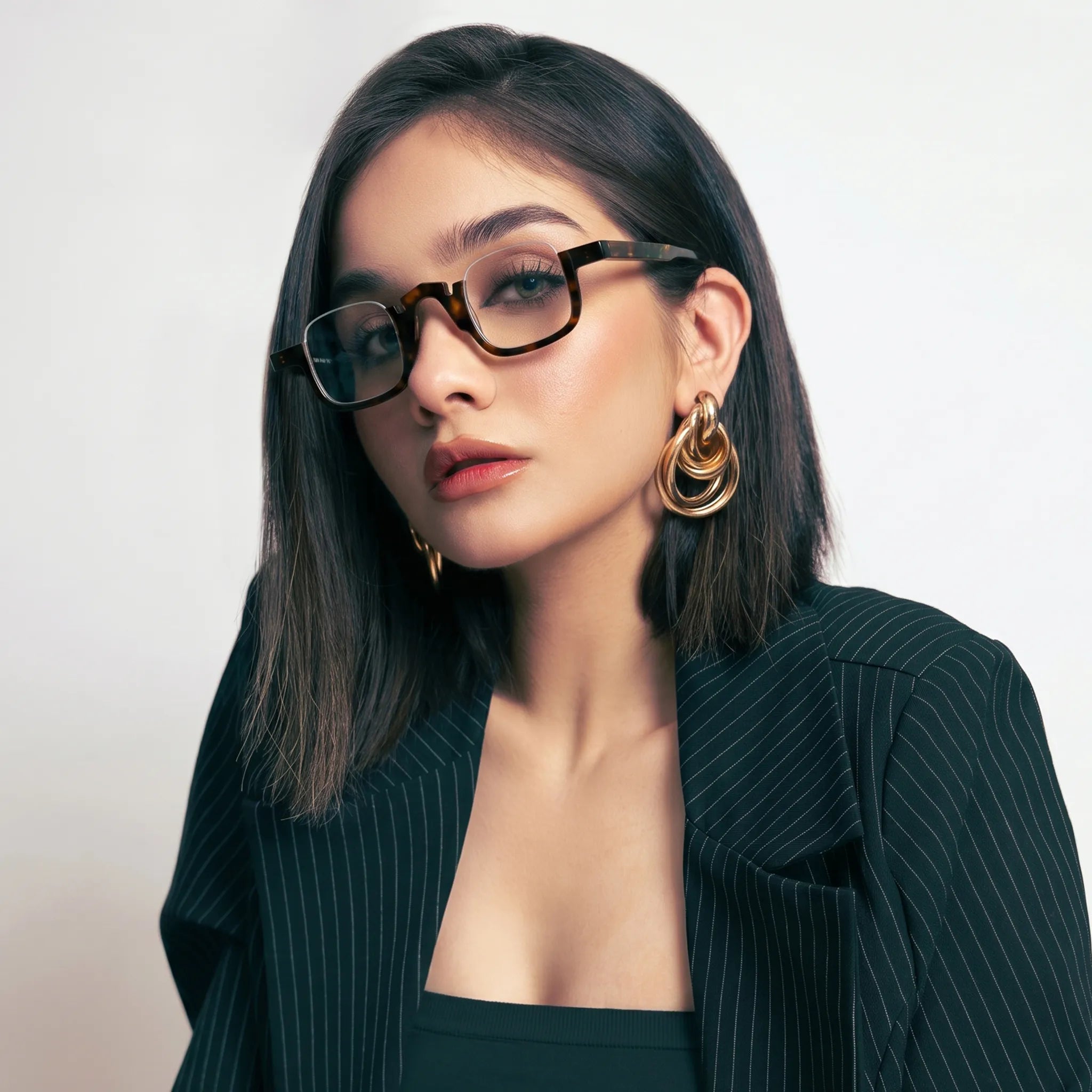 Model wearing VL19352 Warm Tortoise semi-rimless square eyeglasses, showing the fit and distinctive tortoise acetate prescription frame.
