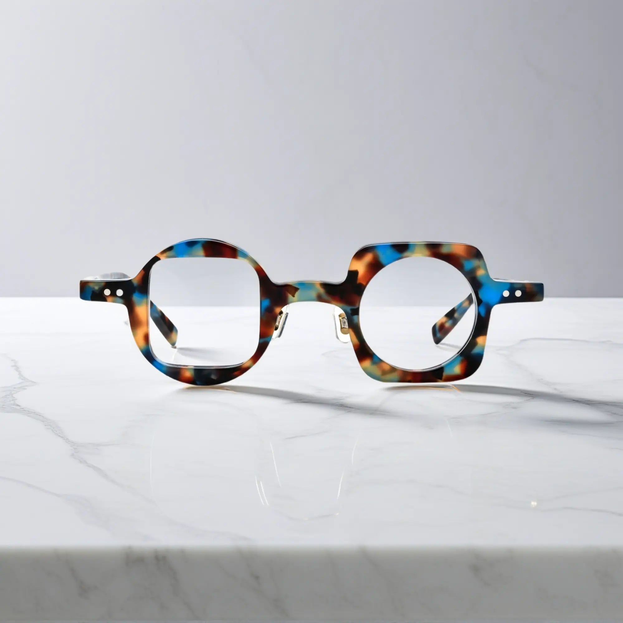 Front view of VoyueLens asymmetrical eyeglasses in blue tortoise acetate, featuring nano-polished finish and artistic unisex design.