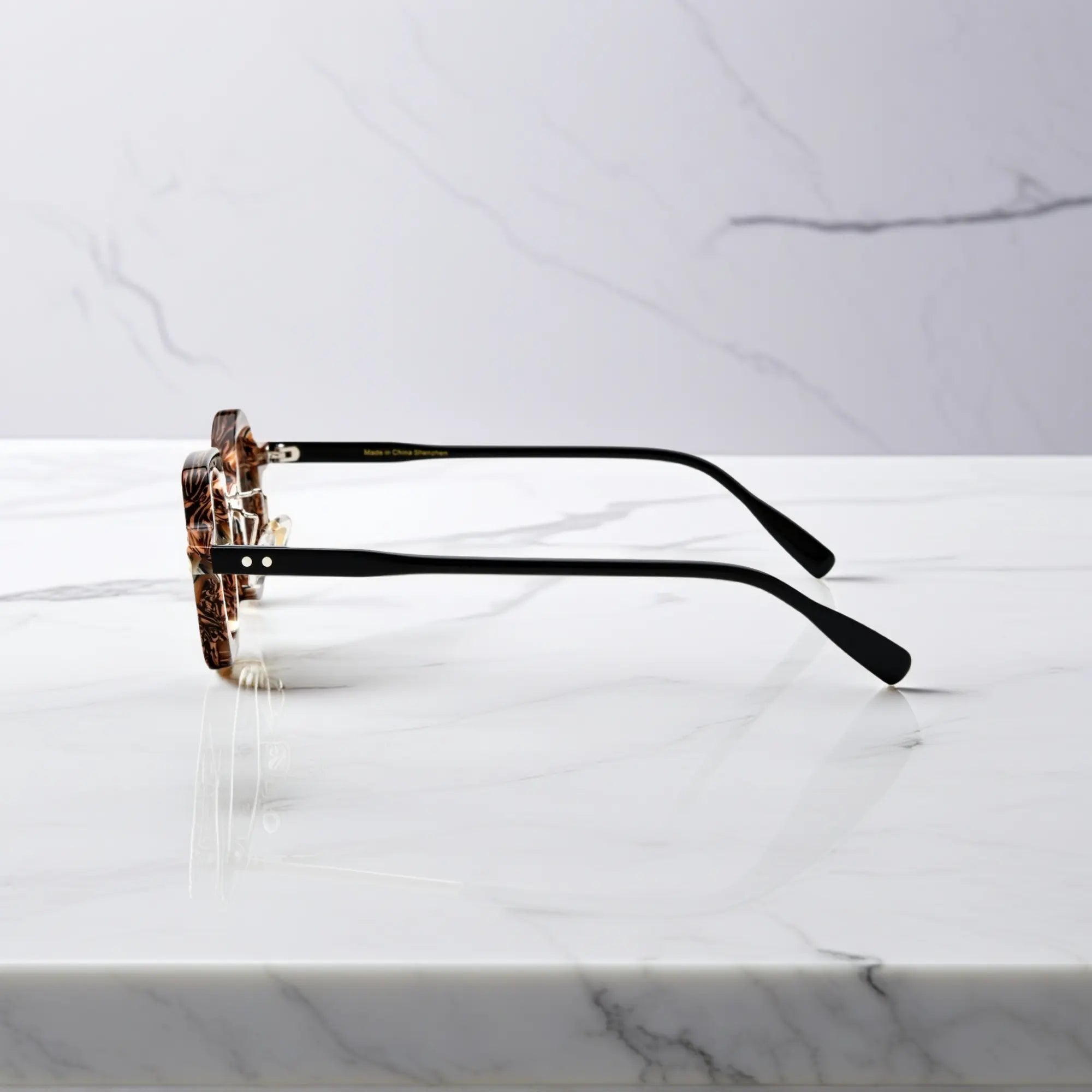 Side profile of VoyueLens asymmetrical brown stripe glasses showing nano-polished acetate frame, ergonomic silicone nose pads, and black temples