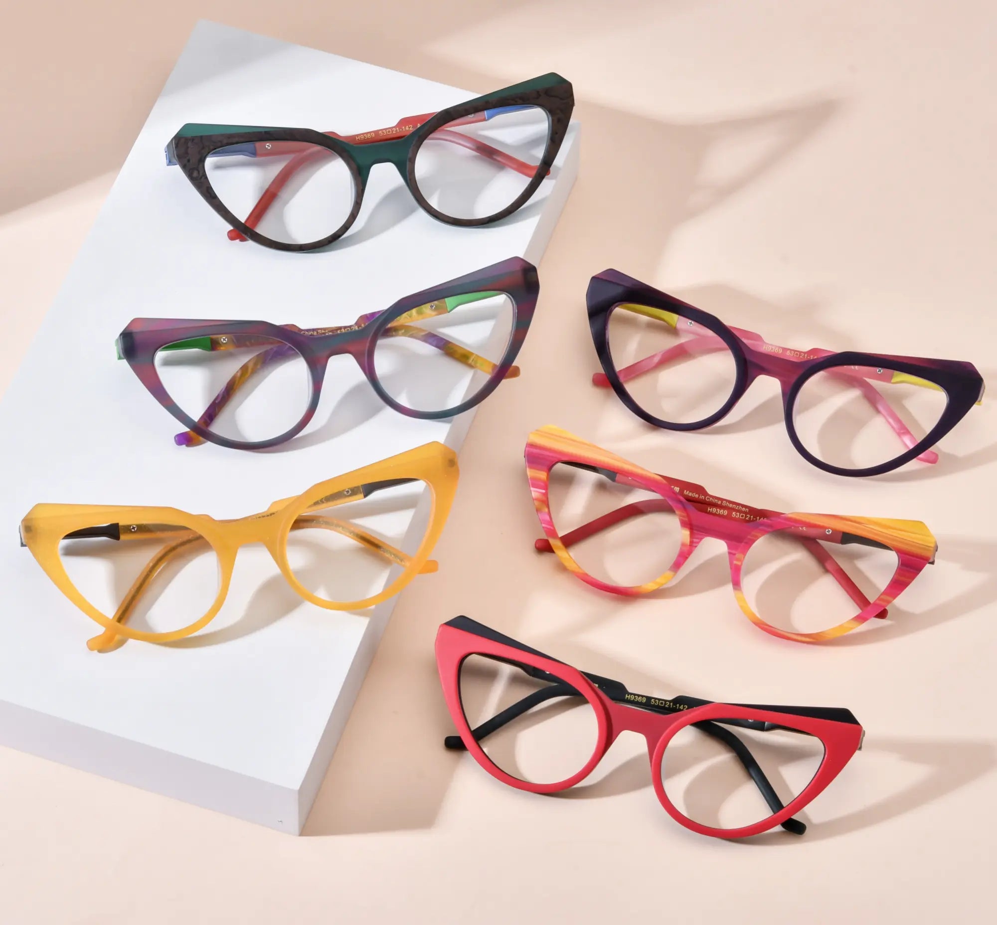 Flatlay image showing the full VoyueLens™ VL19369 butterfly eyeglasses collection in six vibrant colors — Forest Marble, Aurora Fade, Citrus Amber, Plum Velvet, Rainbow Stripe, and Crimson Nebula. Each frame features a bold cat-eye shape crafted from lightweight matte acetate, highlighting the playful and artistic color combinations ideal for fashion-forward individuals.