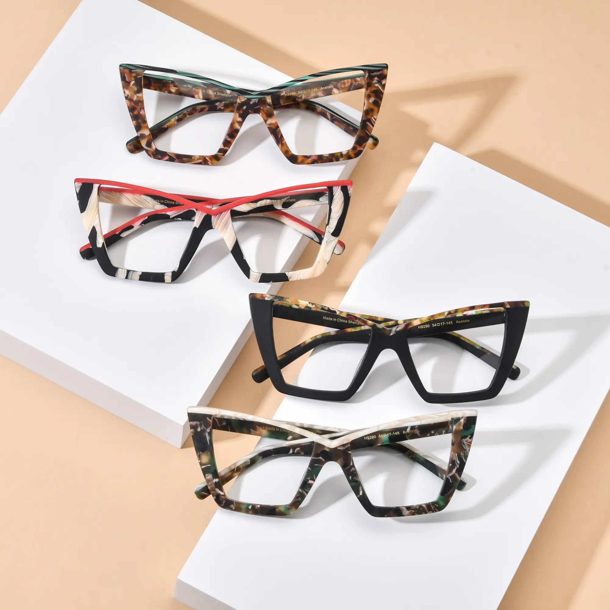 VoyueLens™ oversized cat-eye glasses full color collection, showcasing four unique acetate frames including Emerald Tortoise, Scarlet Ivory Feather, Black-Blue Accent, and Olive Tortoise. This top-down group view highlights the bold butterfly frame design, premium acetate construction, and stylish color options for fashion-conscious women and professionals.
