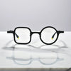Bold front view of Charcoal Black eyeglasses with matte acetate front and titanium arms.