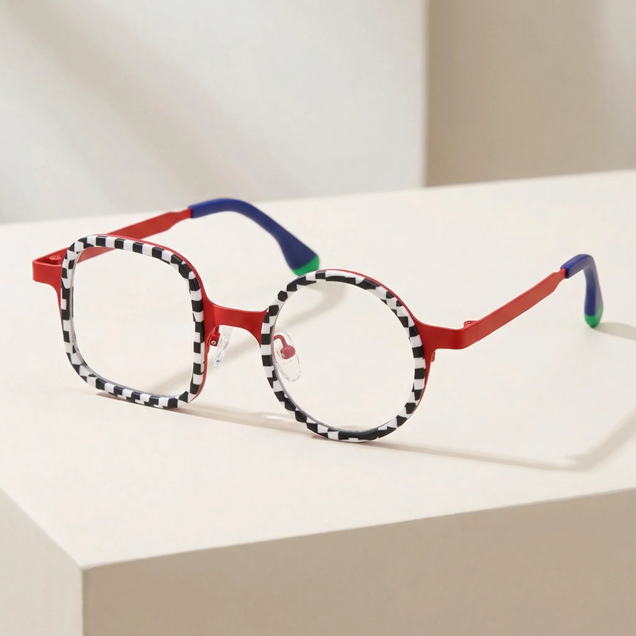Angled view of VoyueLens Checker Clash Red eyeglasses highlighting artistic square-round frame design with checker pattern and vibrant red structure, designed by BARLEDEAR.