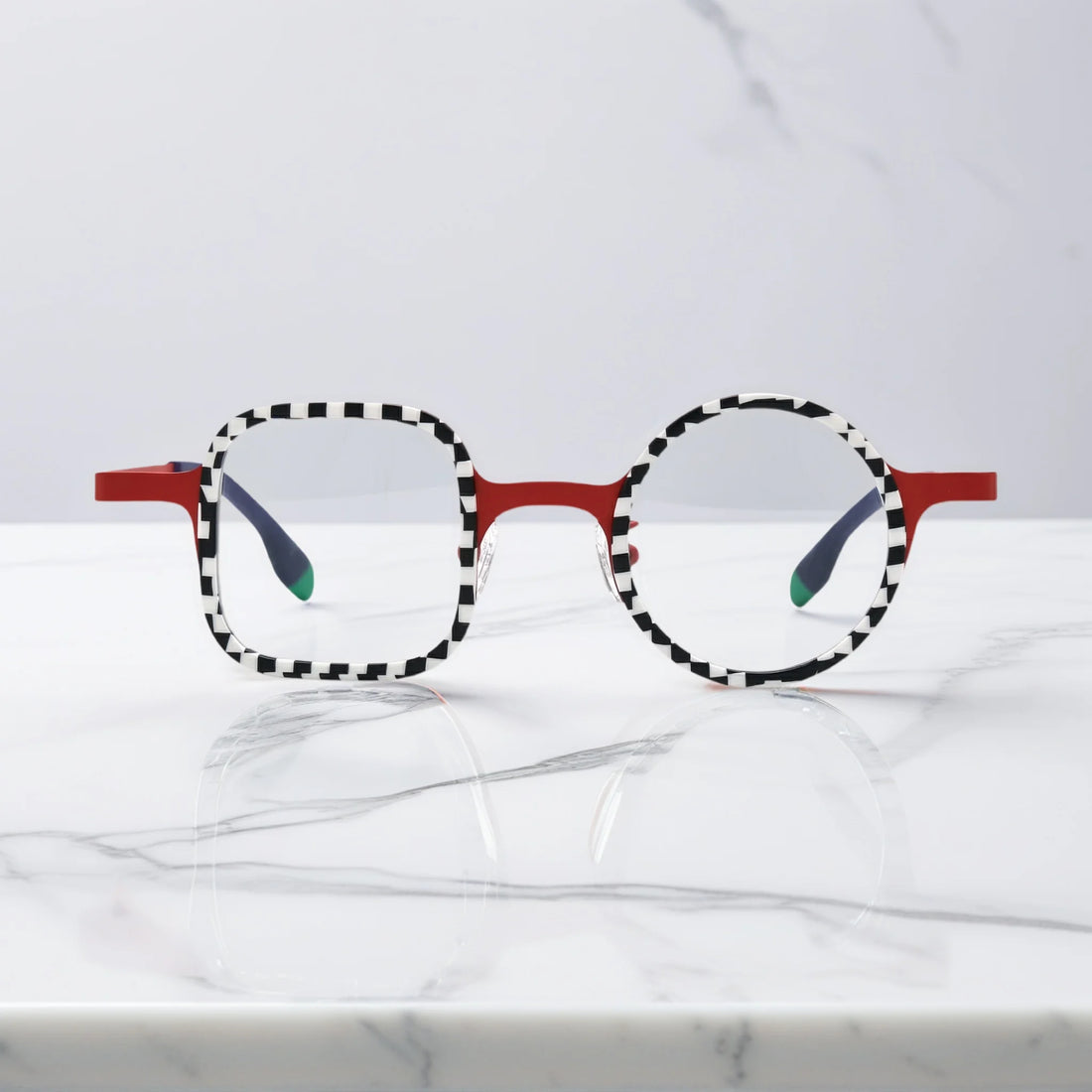 Front view of VoyueLens Checker Clash Red eyeglasses with high-contrast checker rims and asymmetrical dual-shape frame, part of the BARLEDEAR collection.