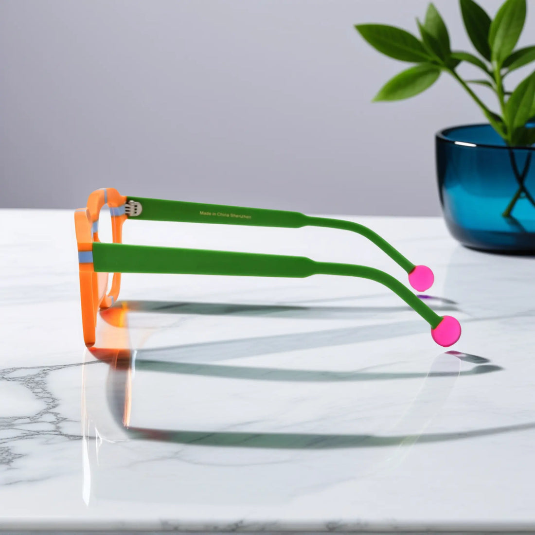 Side view of VoyueLens™ Citrus Pop eyeglasses showing vibrant orange frame, green temples, and pink tips
