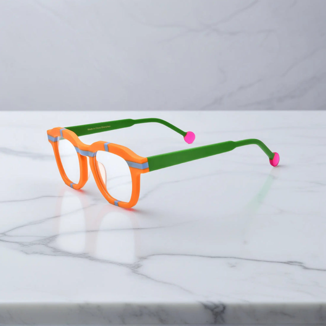 Side view of VoyueLens™ Citrus Pop eyeglasses showing vibrant orange frame, green temples, and pink tips