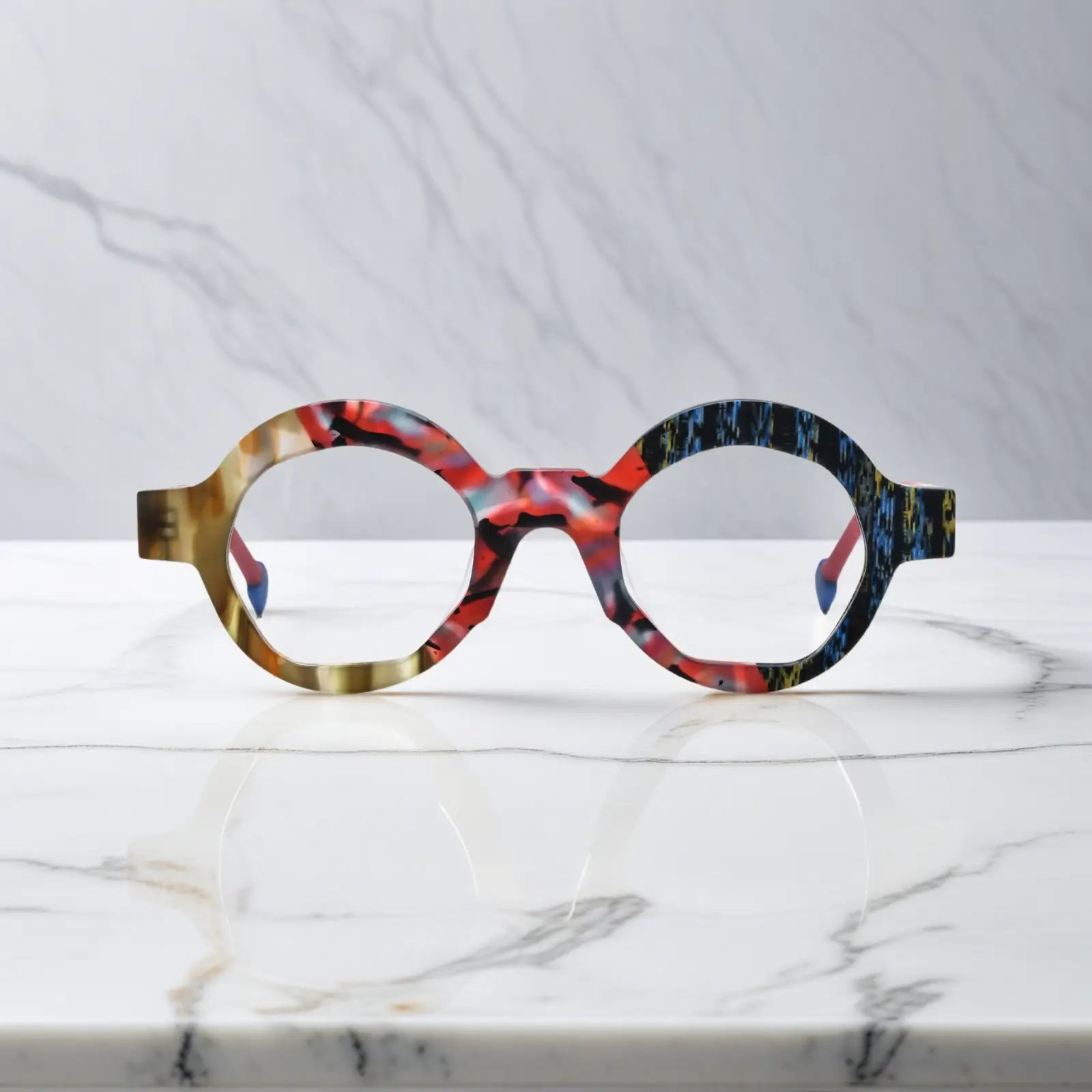 Front-facing image of Crimson Nebula polygon eyeglasses by VoyueLens™, swirling red matte finish with bold artistic lines