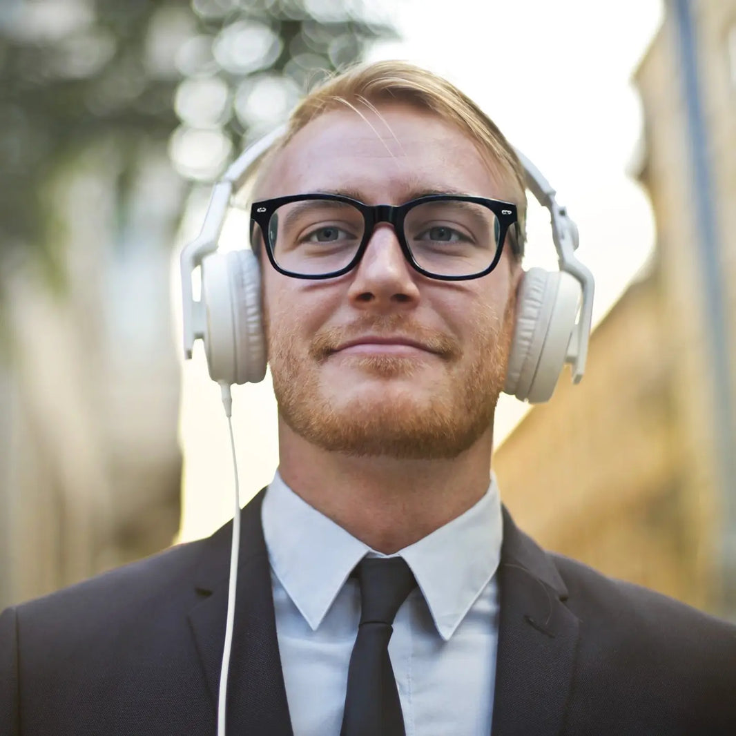 man wearing VoyueLens™ KA62 black frame eyeglasses while listening to music with over-ear headphones
