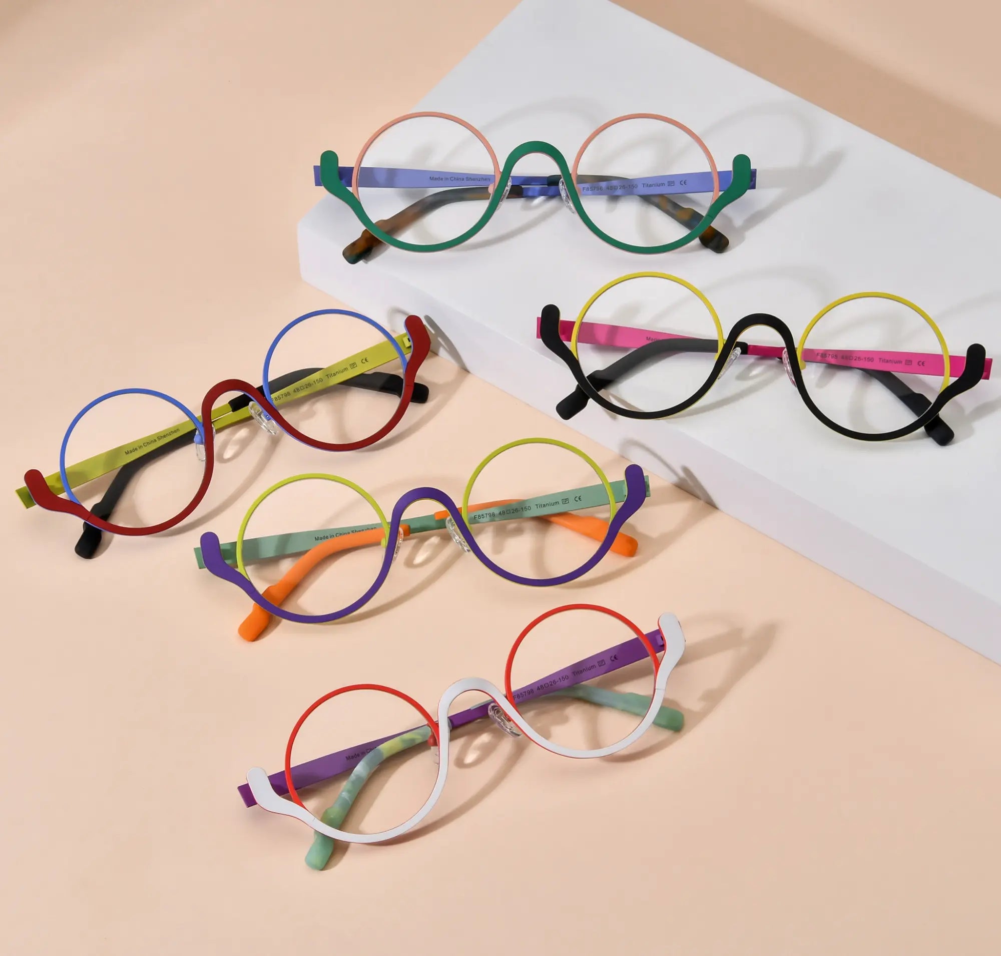 Flatlay image of VoyueLens™ ChromoPop eyeglasses – all five color variants (Pastel Forest, Crimson Ice, Neon Grove, Electric Rust, Lemon Graphite) displayed on beige background