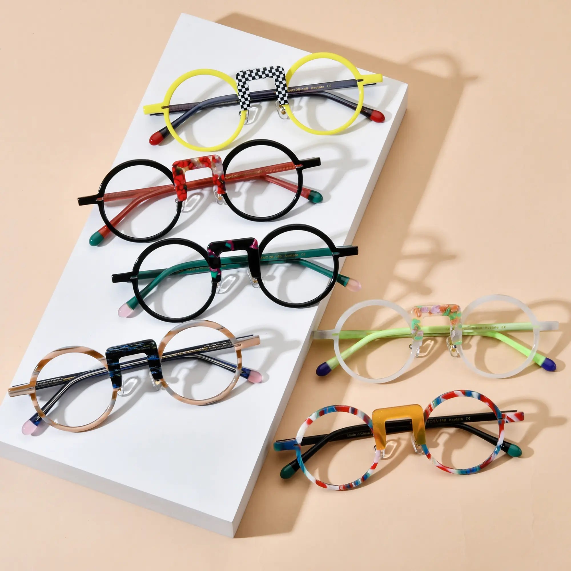 Flatlay image of six color variants from VoyueLens™ NeoPop eyeglasses collection, showcasing round acetate frames with unique nose bridge designs
