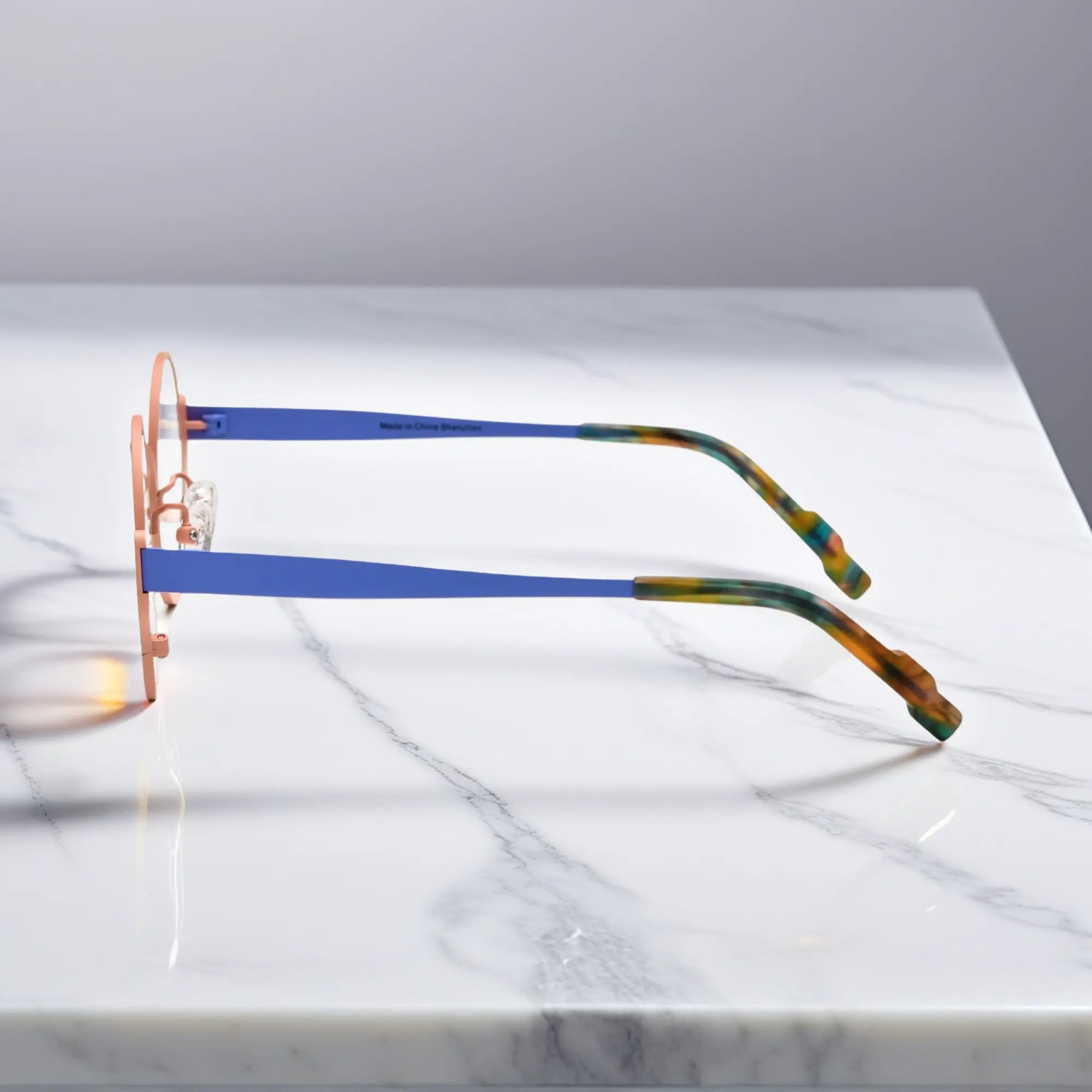 Side profile showing blue titanium temple and tortoiseshell tips – Pastel Forest variant