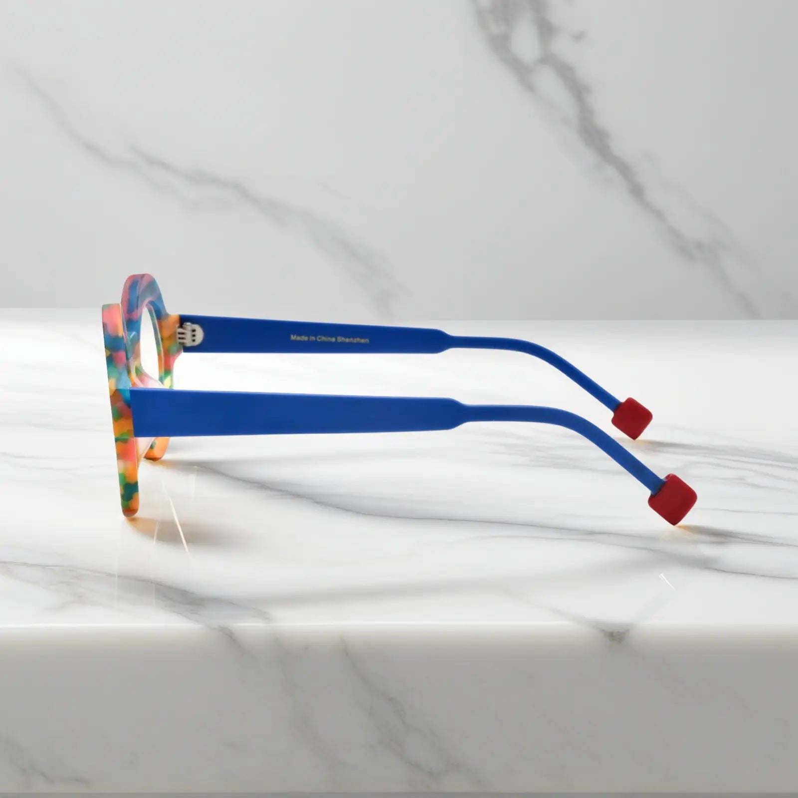 Side profile of Rainbow Stripe VoyueLens™ VL19355 glasses showing multi-color matte acetate temples and geometric polygon silhouette