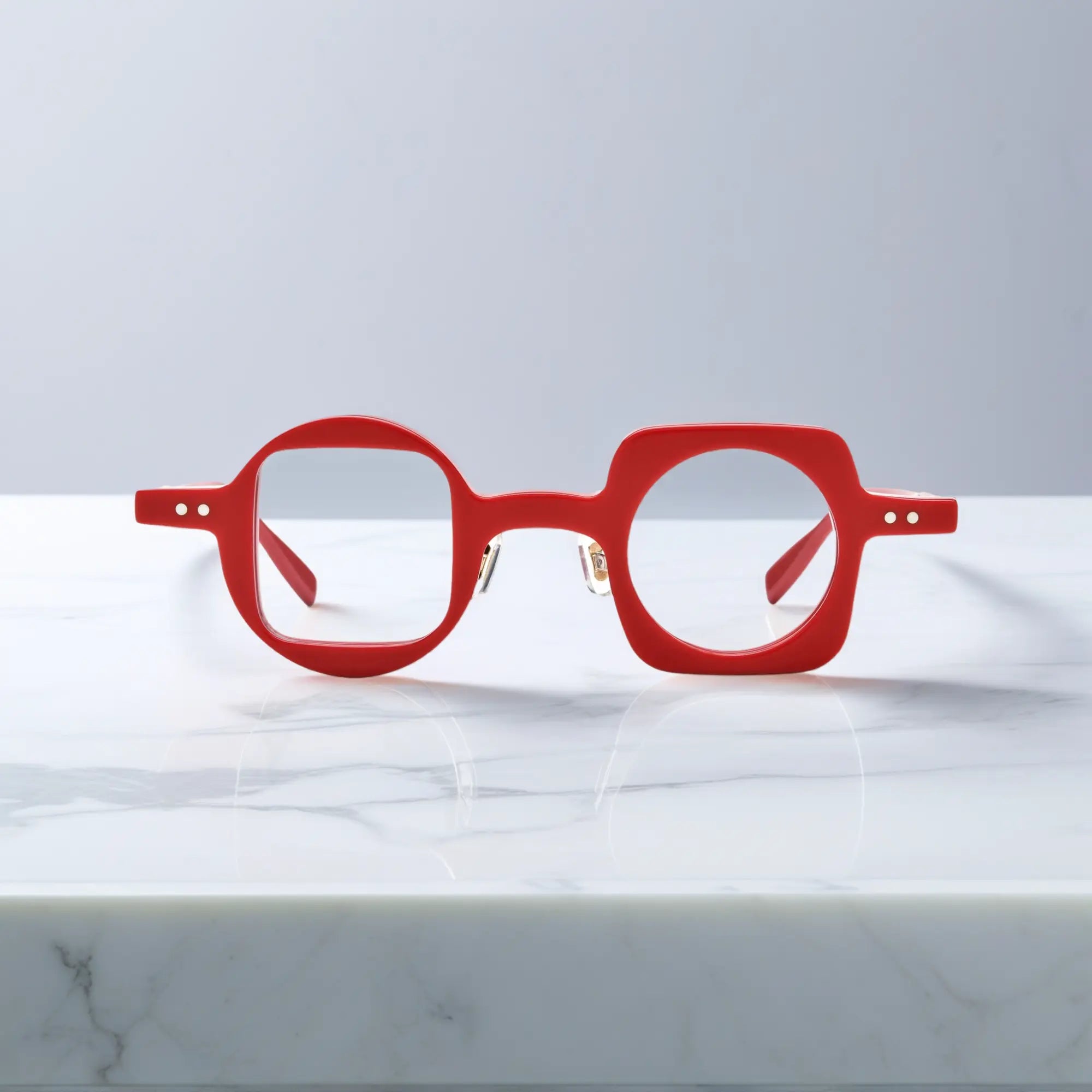Front view of VoyueLens Designer Series asymmetrical eyeglasses in vibrant red acetate with nano-polished surface, designed for unisex use.