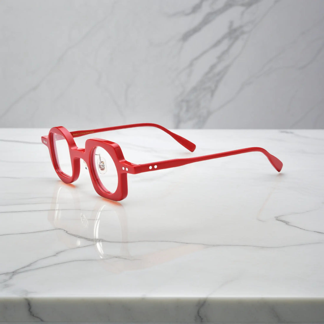 Side angle showcasing VoyueLens red asymmetrical glasses with silicone nose pads and premium acetate construction.