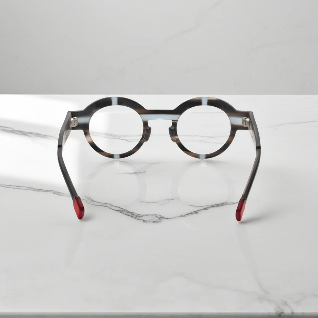 Angled view of slate gray VoyueLens™ glasses showing the round shape and muted matte surface.