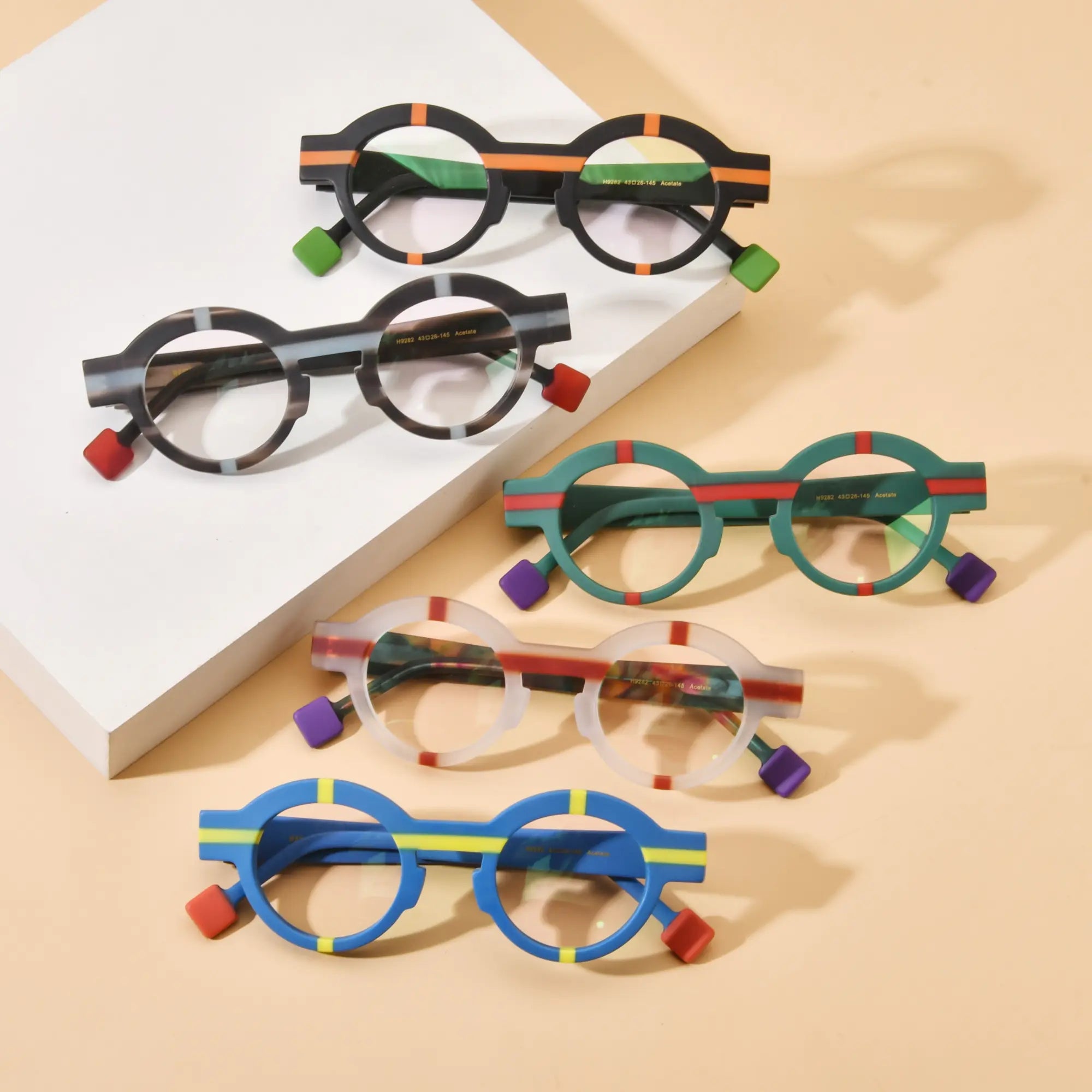 Flat lay display of VoyueLens™ Retro Geometric Round Glasses in five unique colorways, highlighting bold round acetate frames with matte finishes.