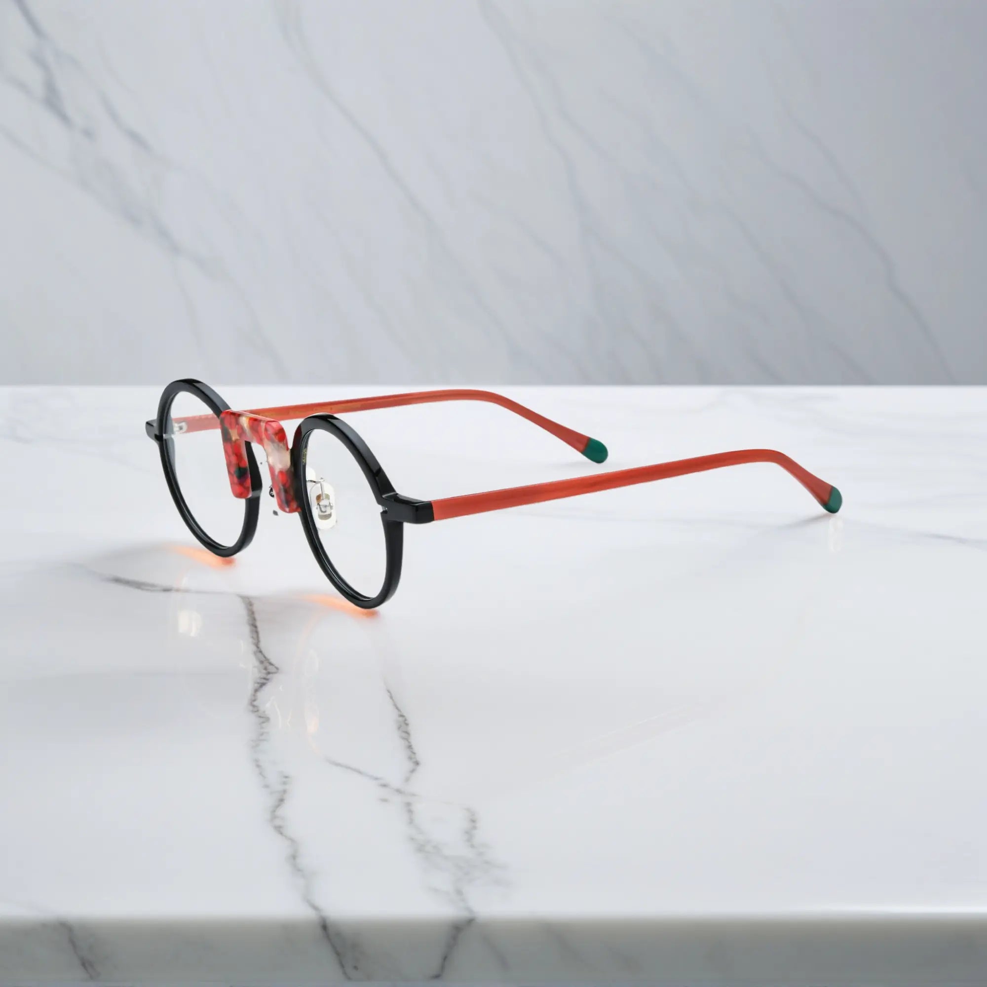 Side angle of Scarlet Noir round acetate eyeglasses with red-black tones