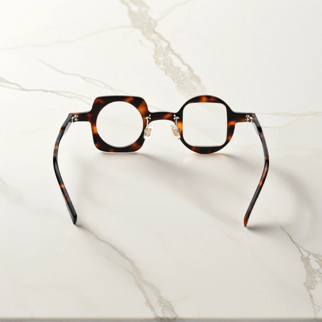 Back view of VoyueLens tortoise asymmetrical glasses with polished acetate finish, silicone nose pads, and durable standard metal hinges.