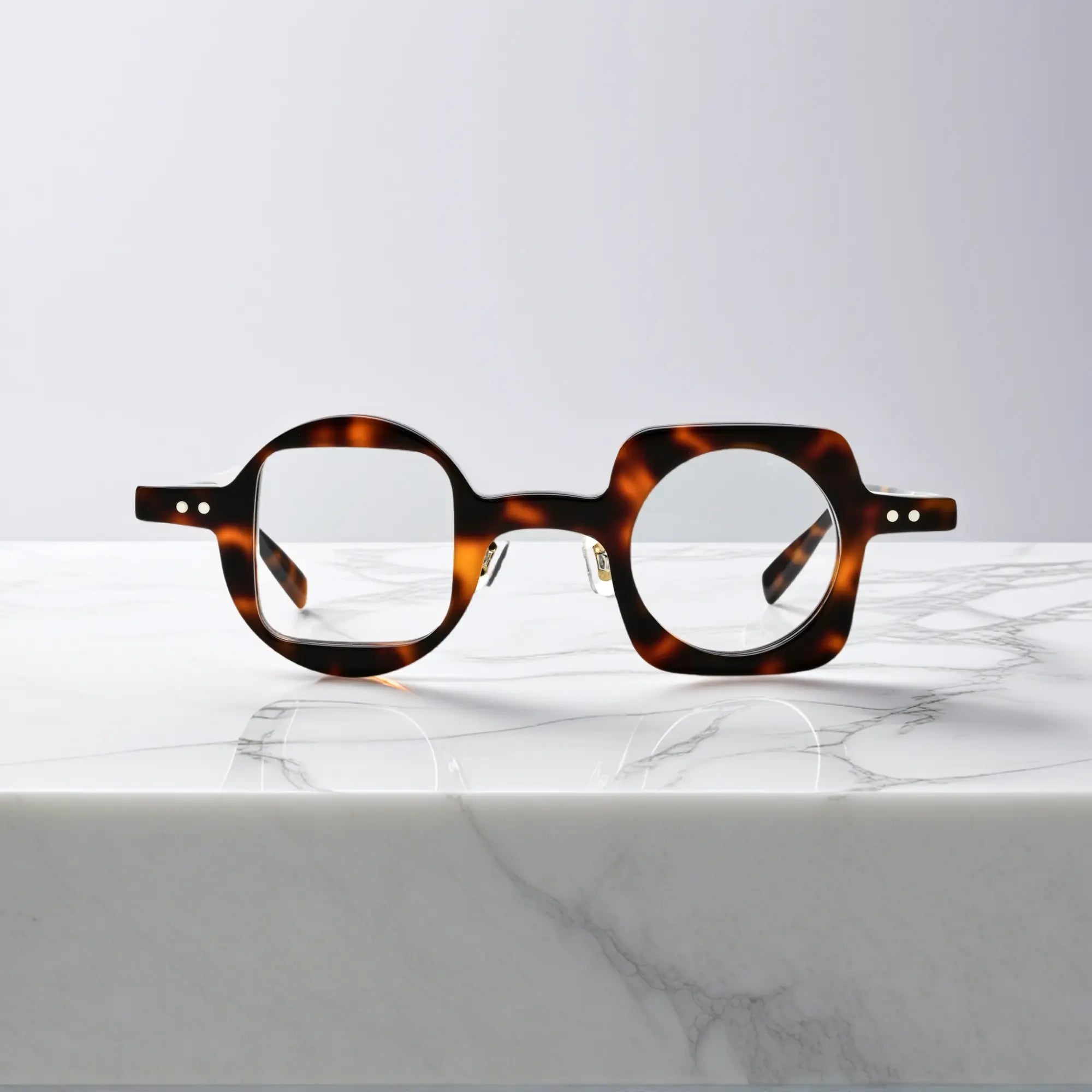 Front view of VoyueLens Designer Series asymmetrical eyeglasses in tortoise acetate, lightweight and nano-polished for fashionable unisex wear.