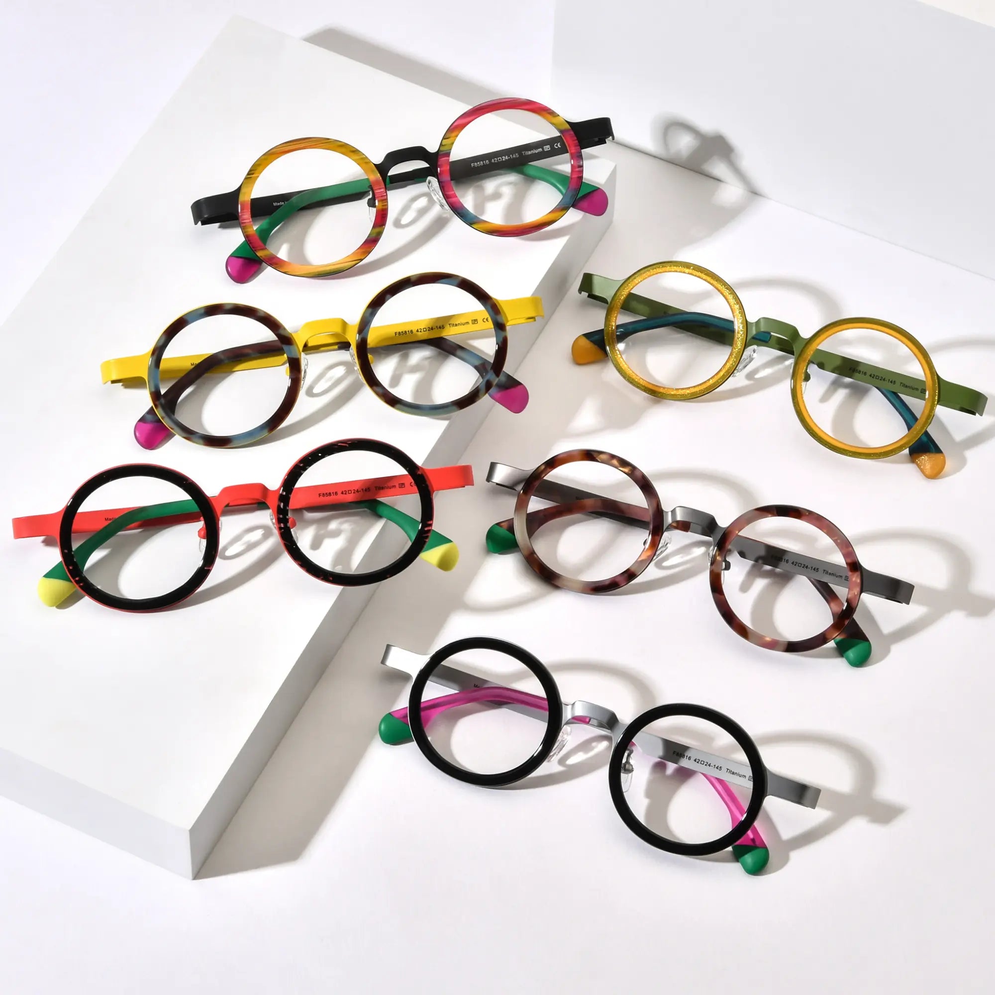 Full collection of VoyueLens™ VL185816 round titanium eyeglasses in six color variants arranged in flatlay display