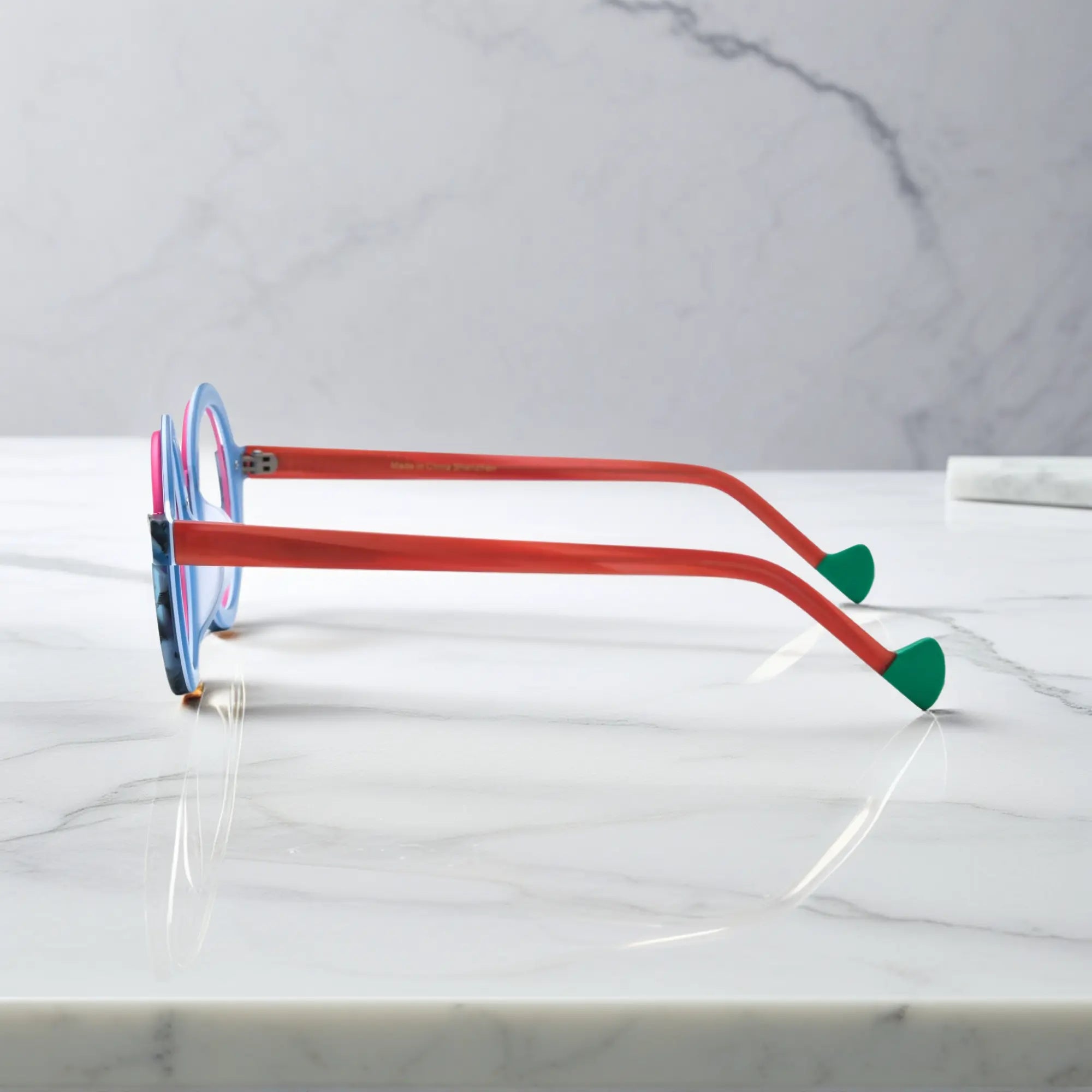 Side profile of VoyueLens™ eyeglass frames in Blue Coral highlighting temple structure and artistic design.