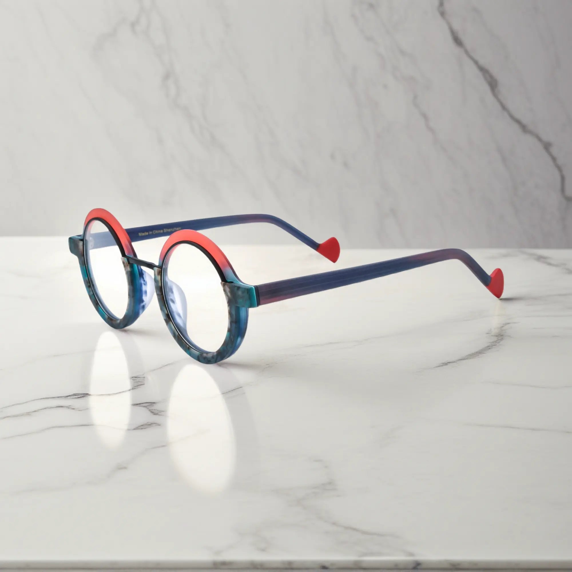 Side angle of VoyueLens™ eyeglass frames in Ocean Blaze highlighting temple structure and artistic design.
