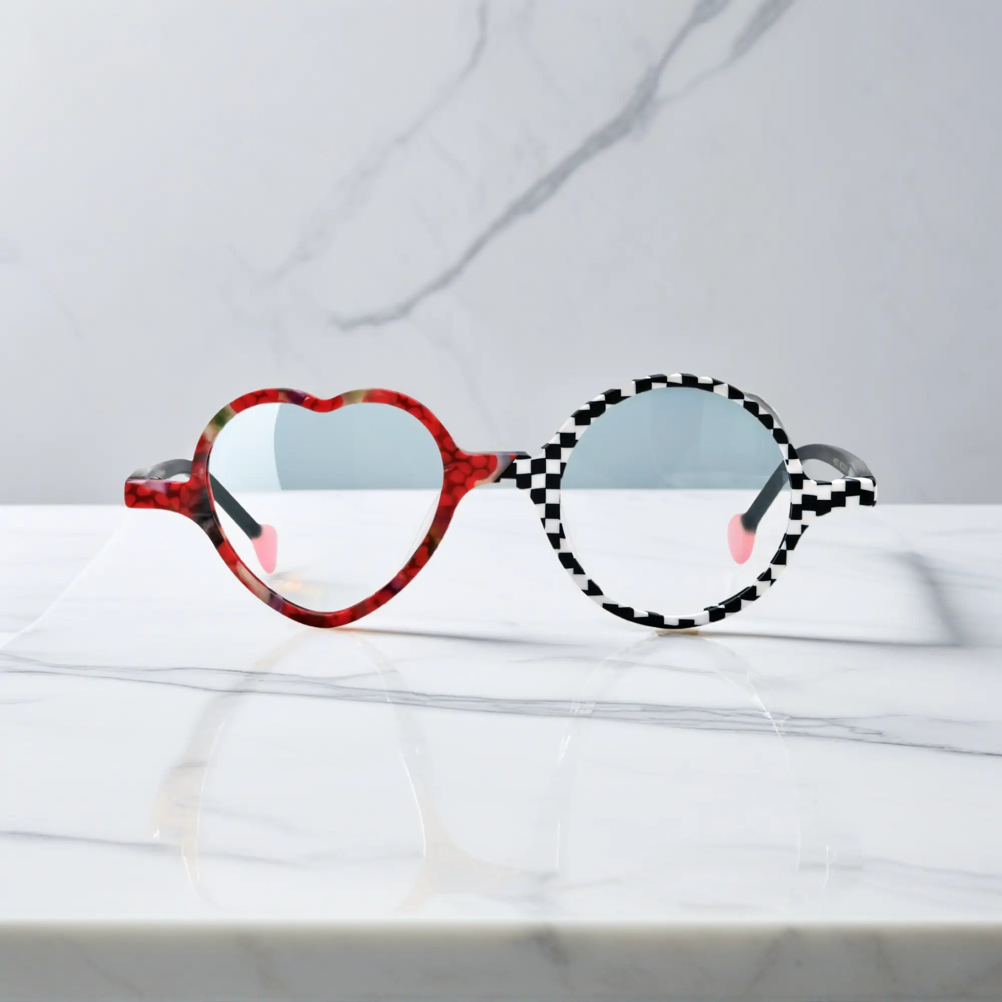 Front view of VoyueLens™ VL19377 in Checker Red Pop, highlighting heart and round lens design. Bold red and black asymmetrical frame with heart and round lenses.