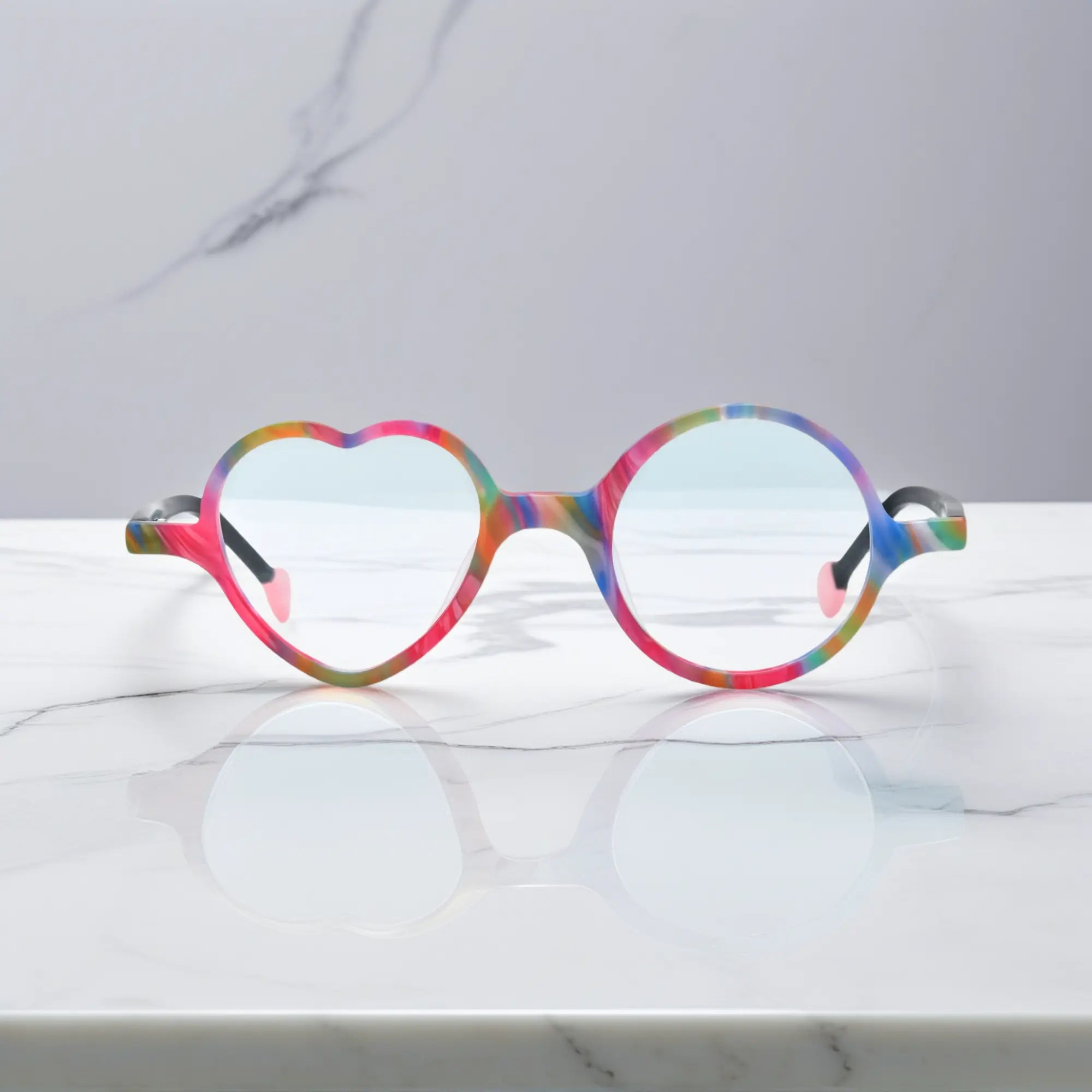 Front view of VoyueLens™ VL19377 in Rainbow Twist, highlighting heart and round lens design. Multi-colored design with a swirl of rainbow shades in matte finish.