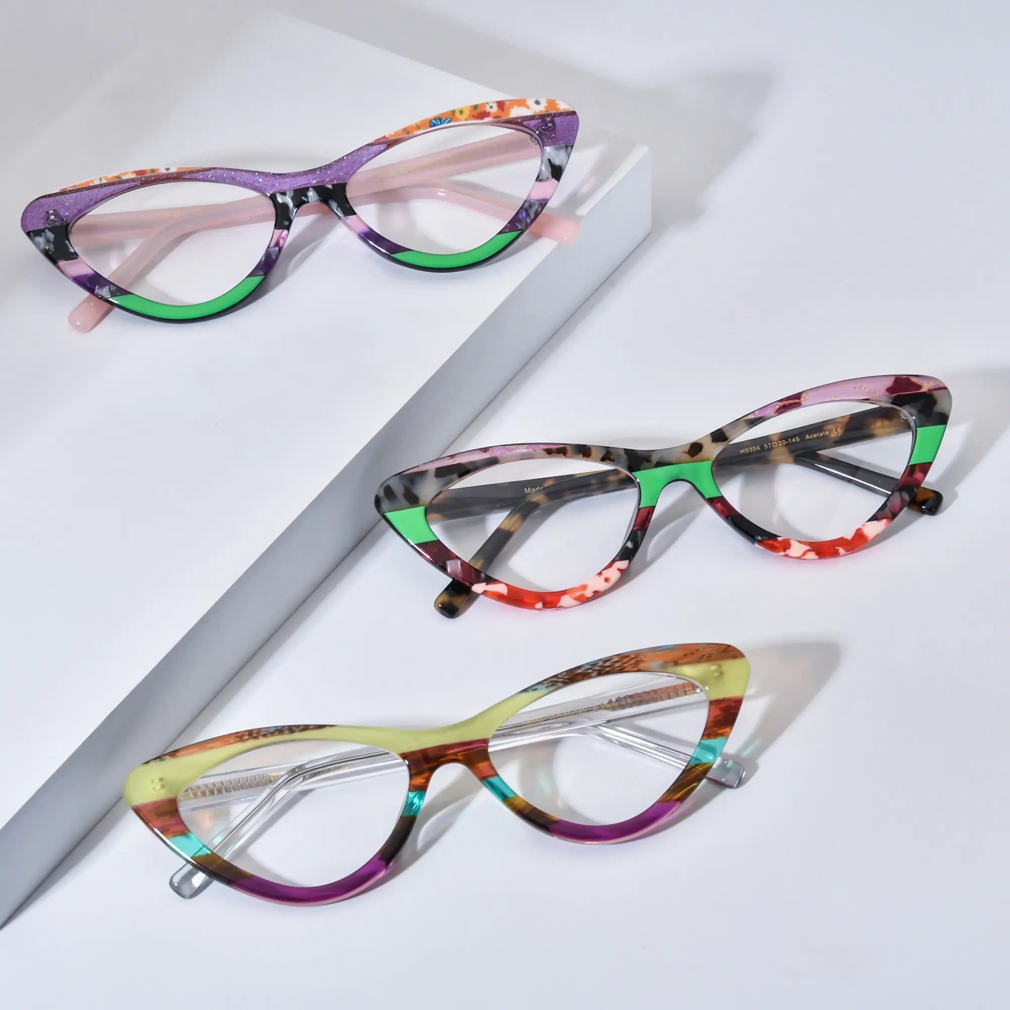 Group view of VoyueLens™ KaleidoCat eyeglasses showing three color variants: Violet Garden (C1), Tortoiseshell Pop (C2), and Sunrise Mirage (C3), arranged diagonally on white background.